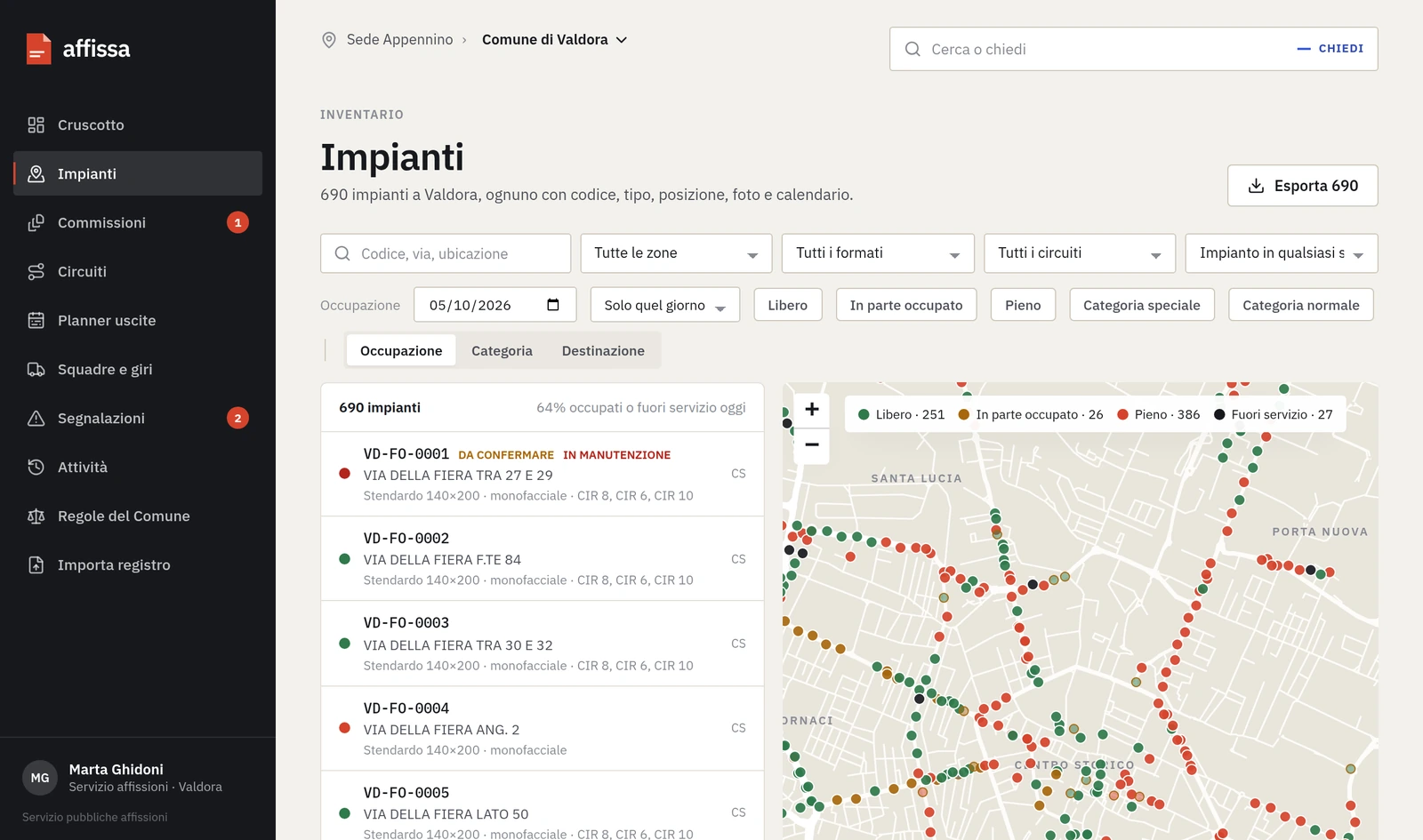 Il prototipo delle pubbliche affissioni: l’elenco degli impianti di un comune inventato, con codice, via e formato, e accanto la mappa con ogni impianto colorato secondo l’occupazione del giorno.